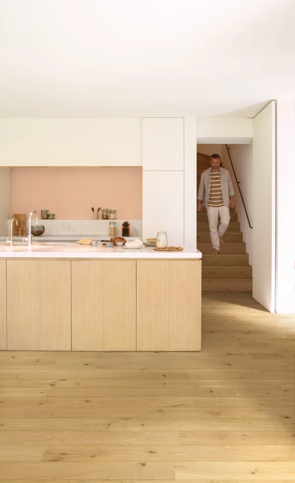 Pale oak slab kitchen island with pink feature wall