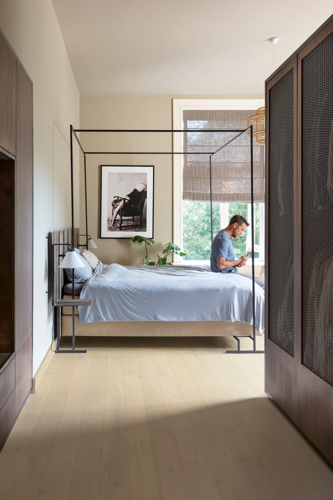 Fitted wardrobes in dark timber beside a four poster bed