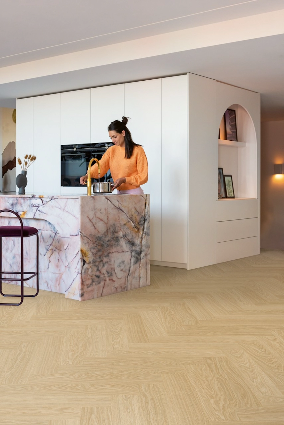 White slab kitchen with marble island and herringbone flooring