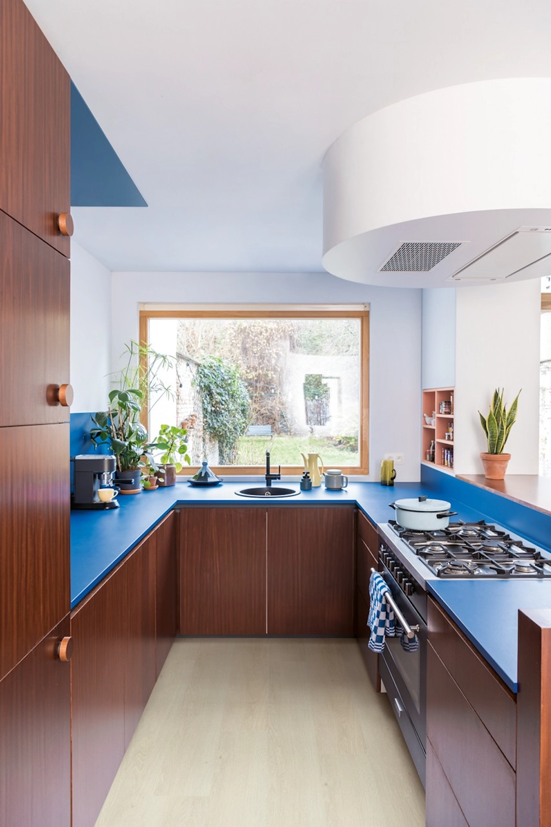 Handleless kitchen in copper and blue with garden window