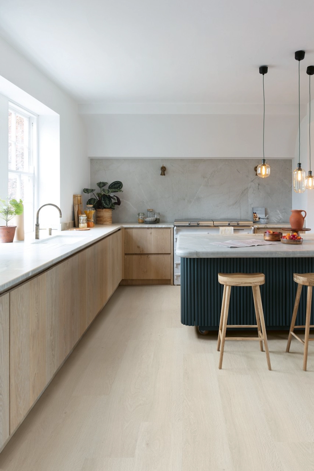 Light oak handleless kitchen with island and bar stools