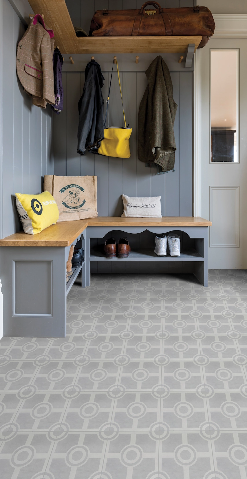 Boot room with fitted bench, coat hooks and patterned tiled floor