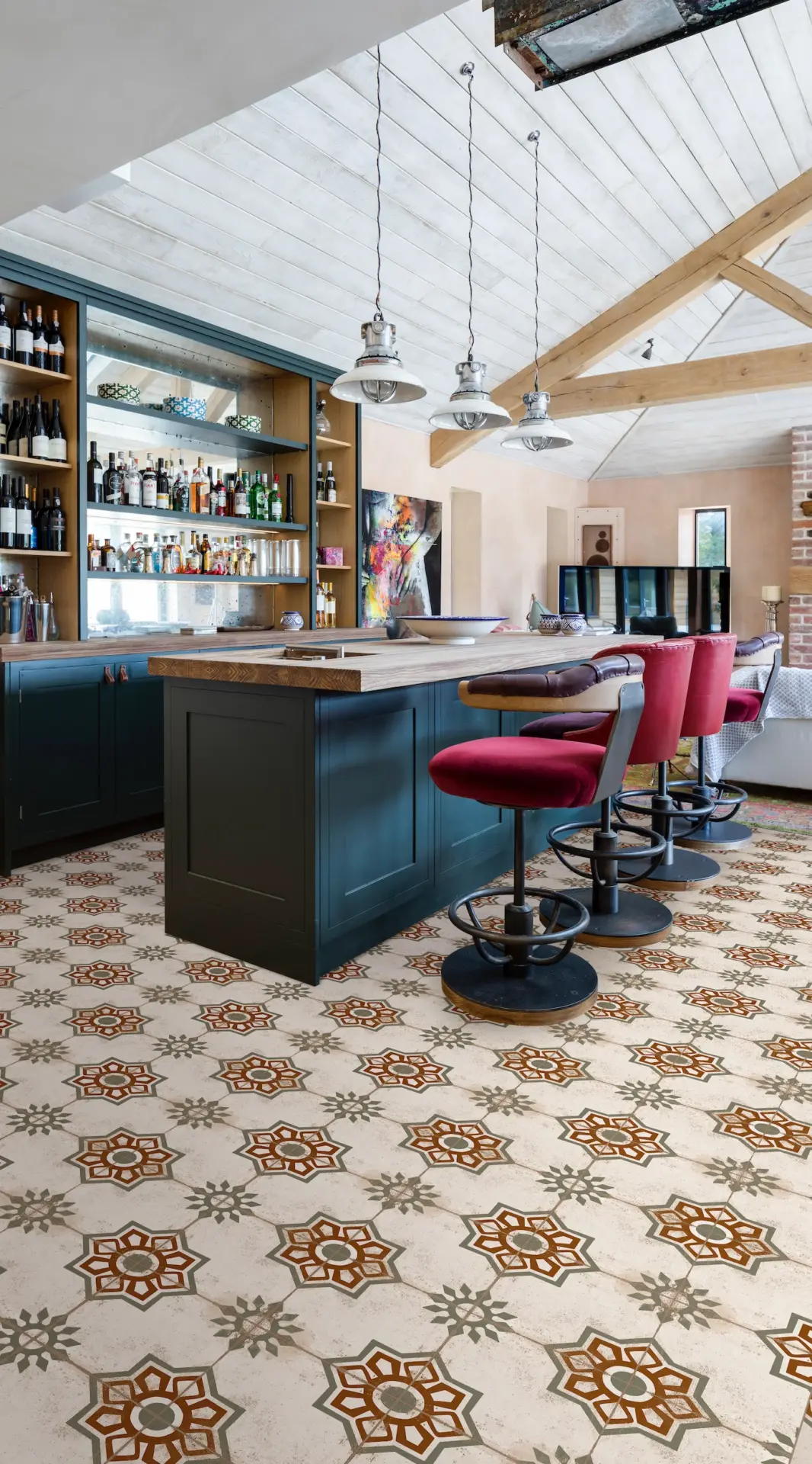 Kitchen bar with teal island, red stools and patterned floor tiles