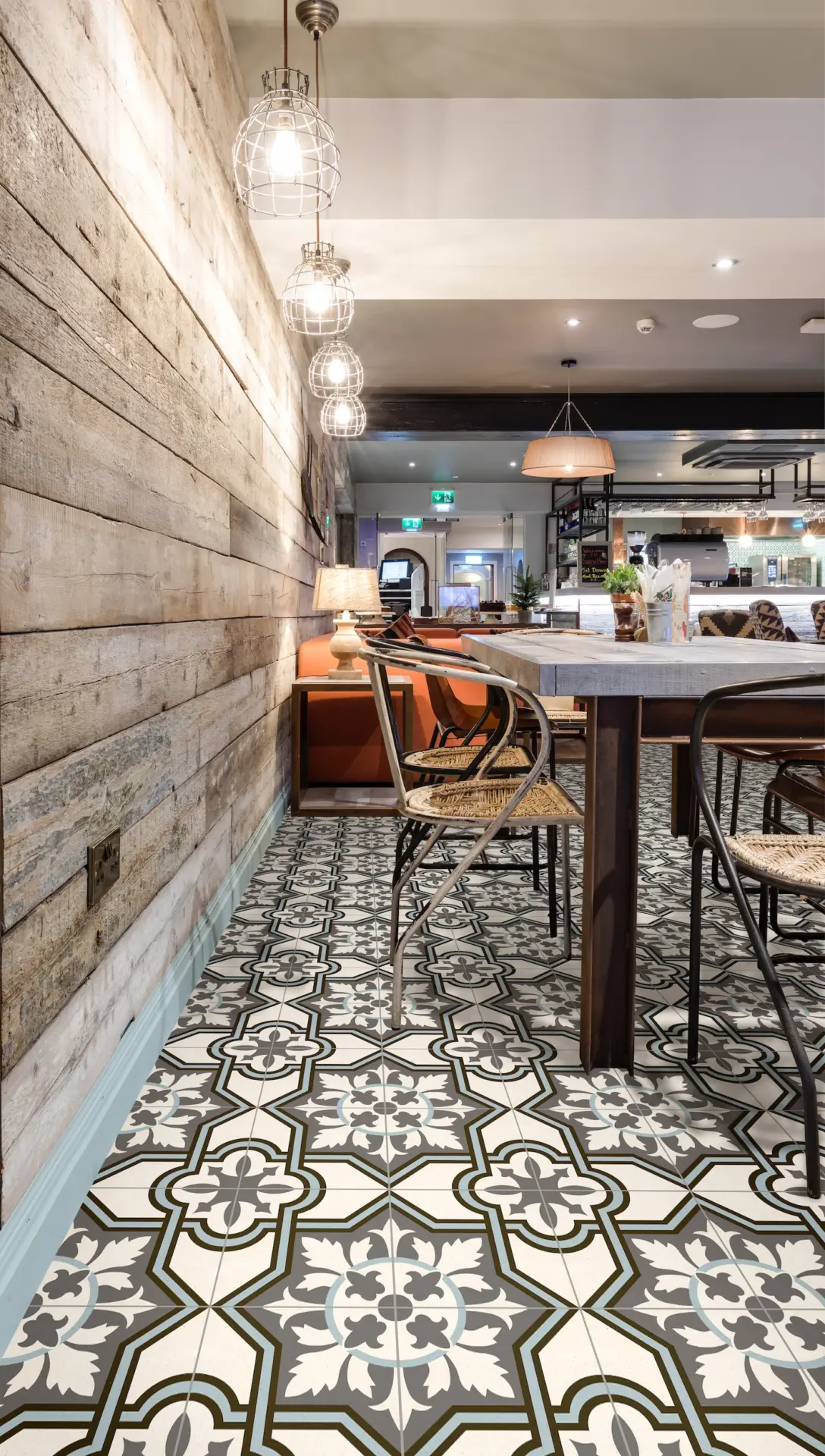 Dining space with reclaimed timber wall and patterned floor tiles