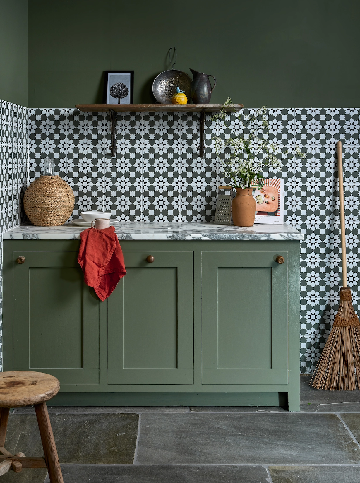 Green shaker utility cabinets with patterned tiles and slate floor