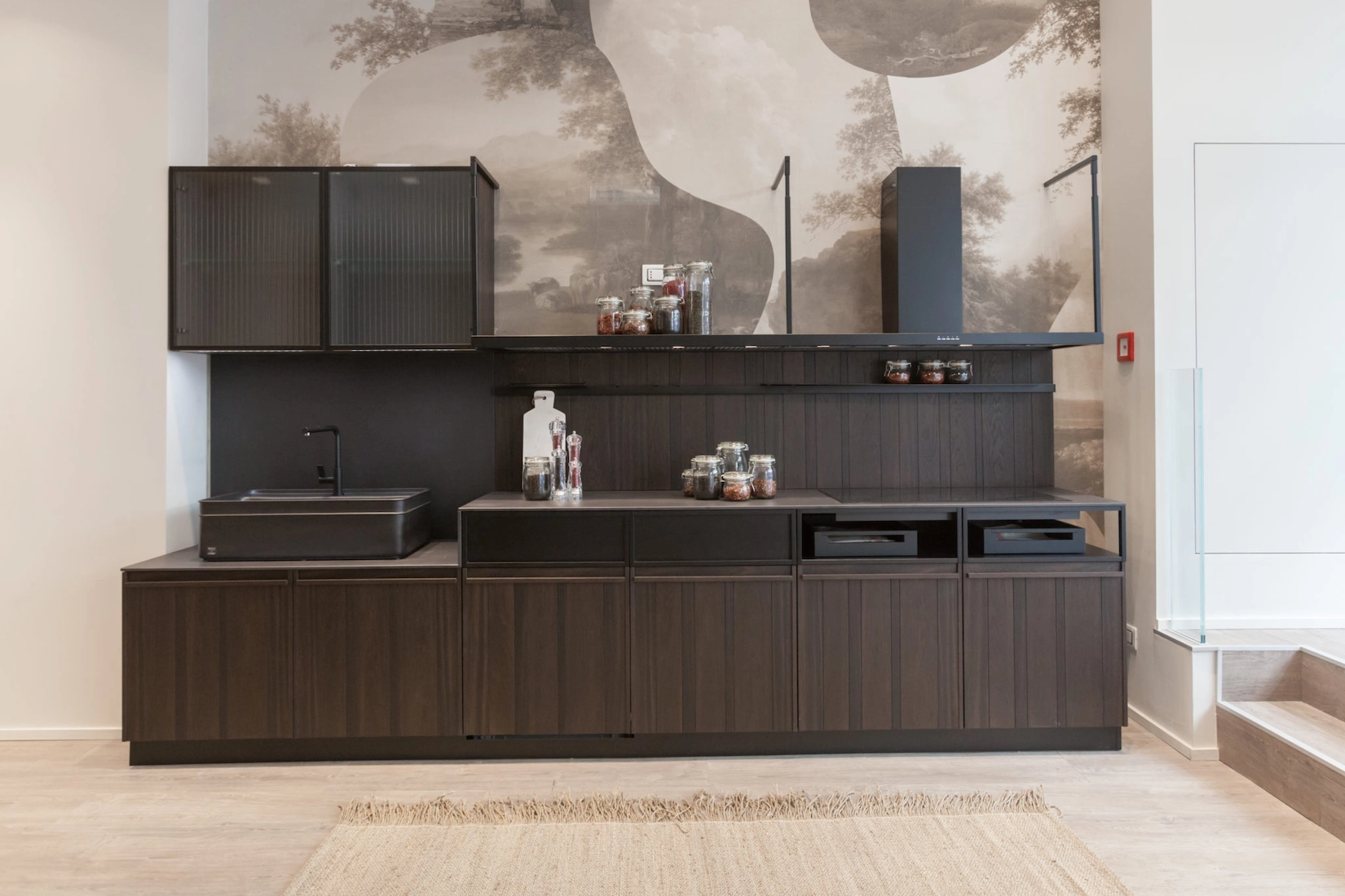 Dark timber handleless kitchen run with decorative mural wall