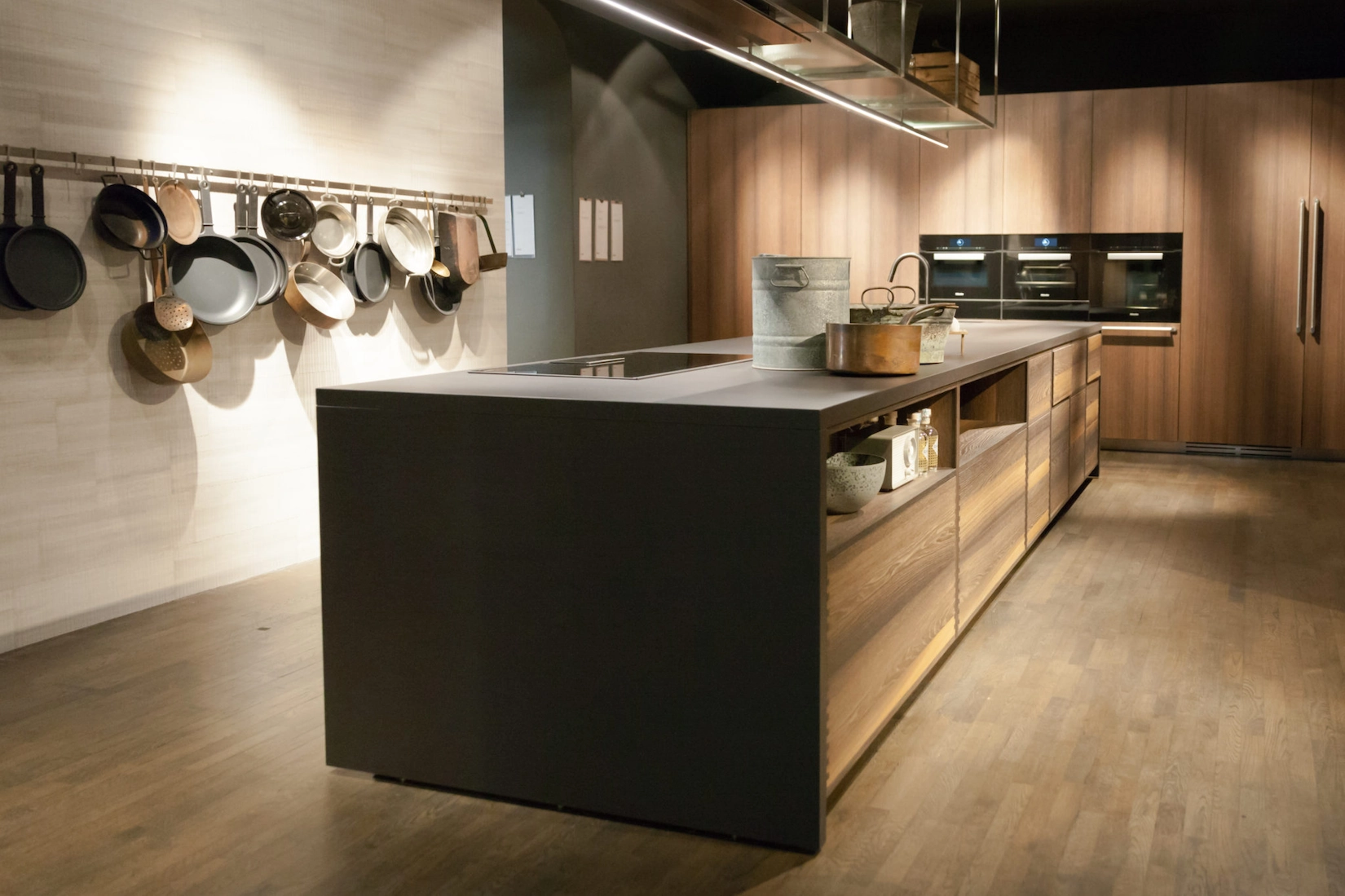 Handleless kitchen in timber with dark island and hanging pan rail