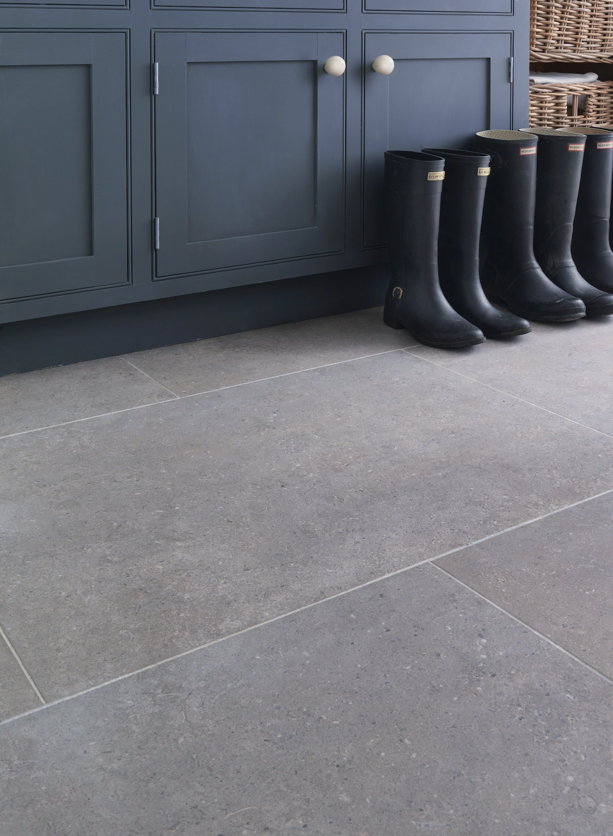 Navy boot room cabinetry with wellington boots and stone floor