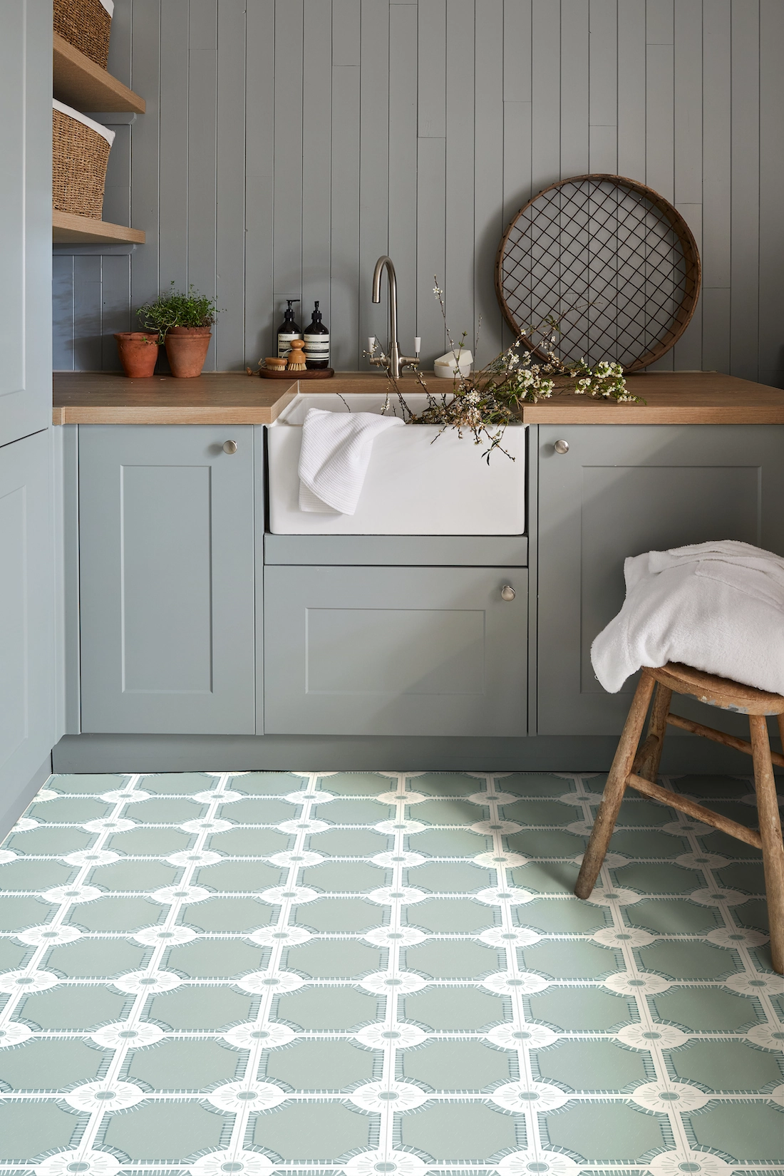 Utility room with butler sink and green patterned floor tiles