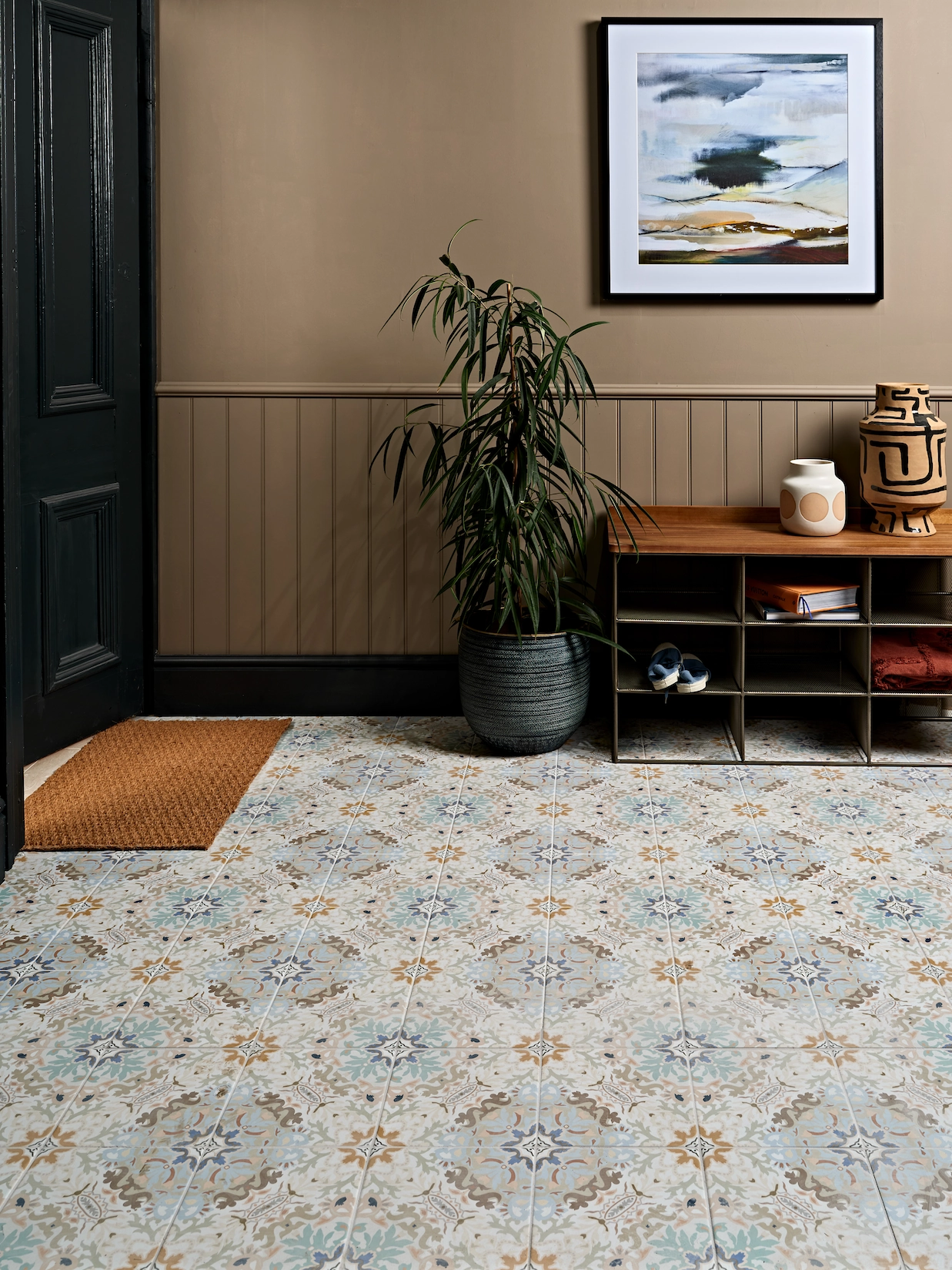 Hallway with patterned encaustic floor tiles and shoe bench