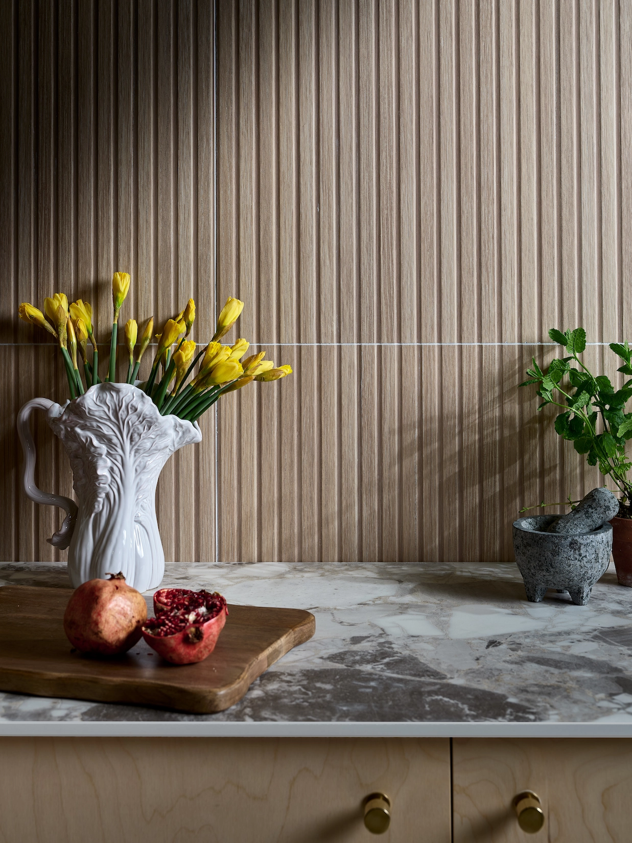 Fluted timber panelling with marble worktop and brass handles