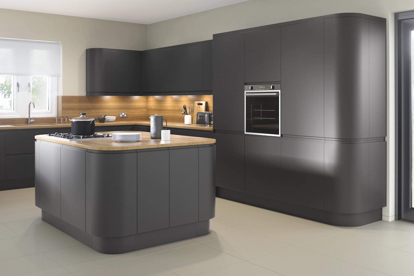 Grey handleless kitchen with curved island and oak worktop