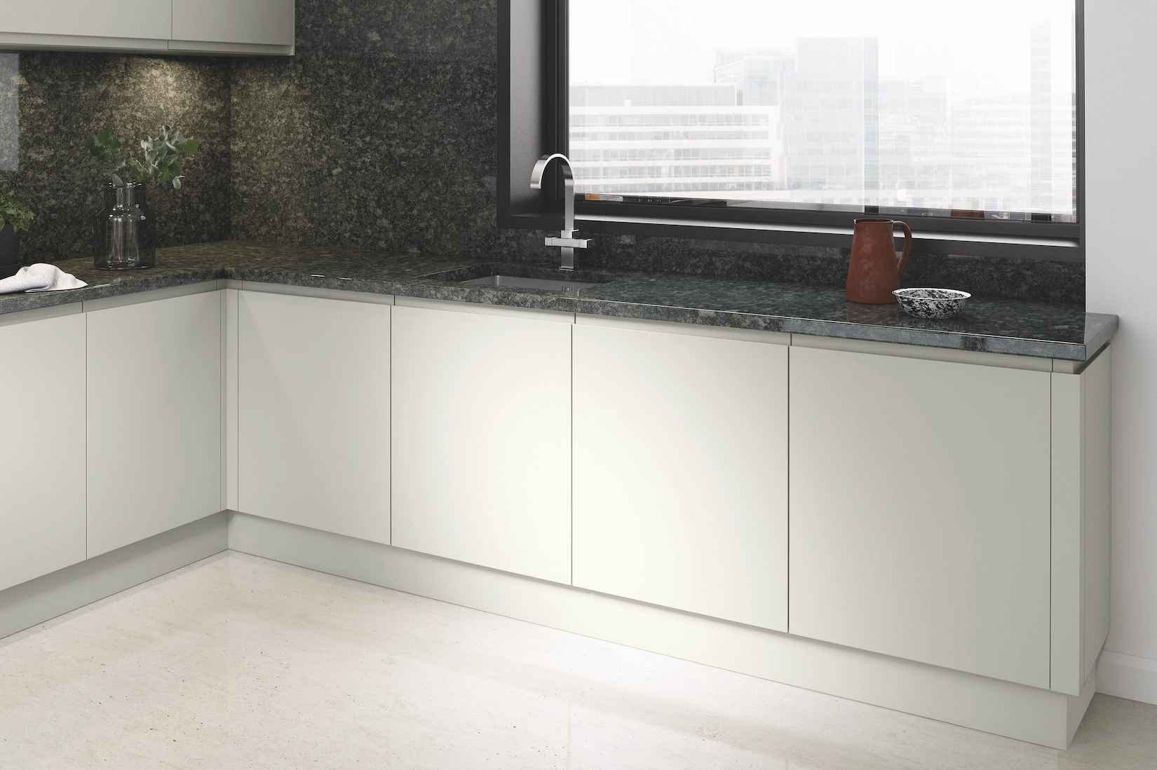 White handleless kitchen with green granite worktop