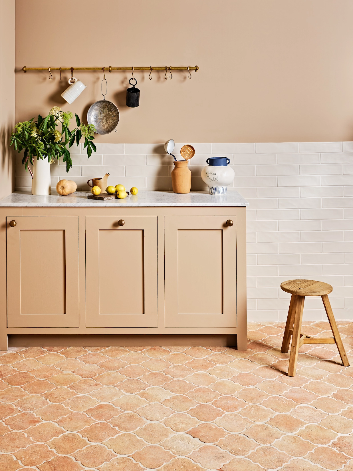 Blush utility cabinets with terracotta tiled floor
