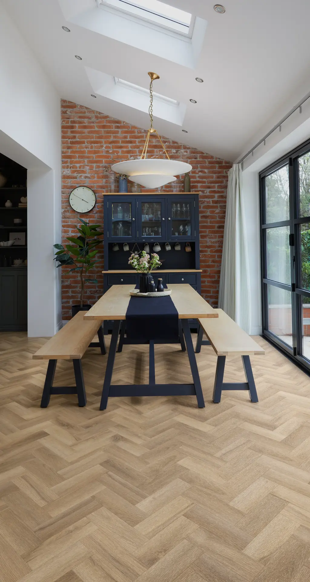 Dining room with exposed brick, herringbone floor and roof lights