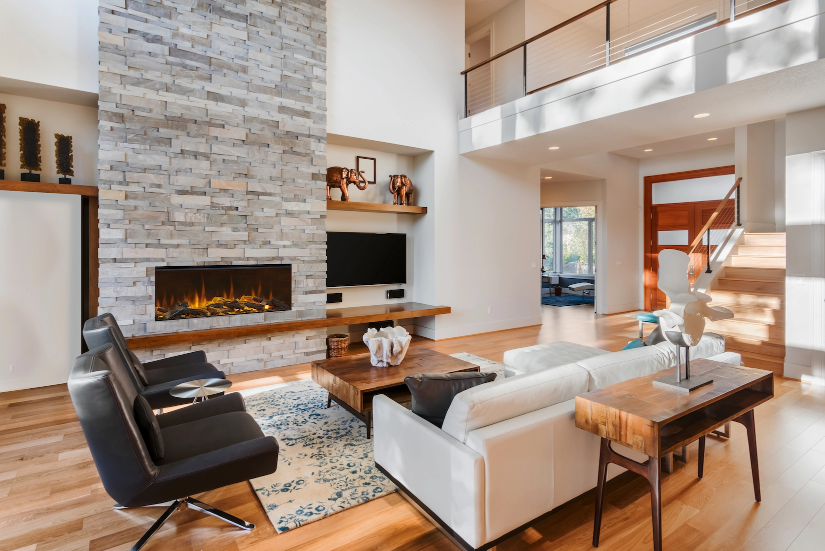 Living room with stone fireplace, linear fire and television