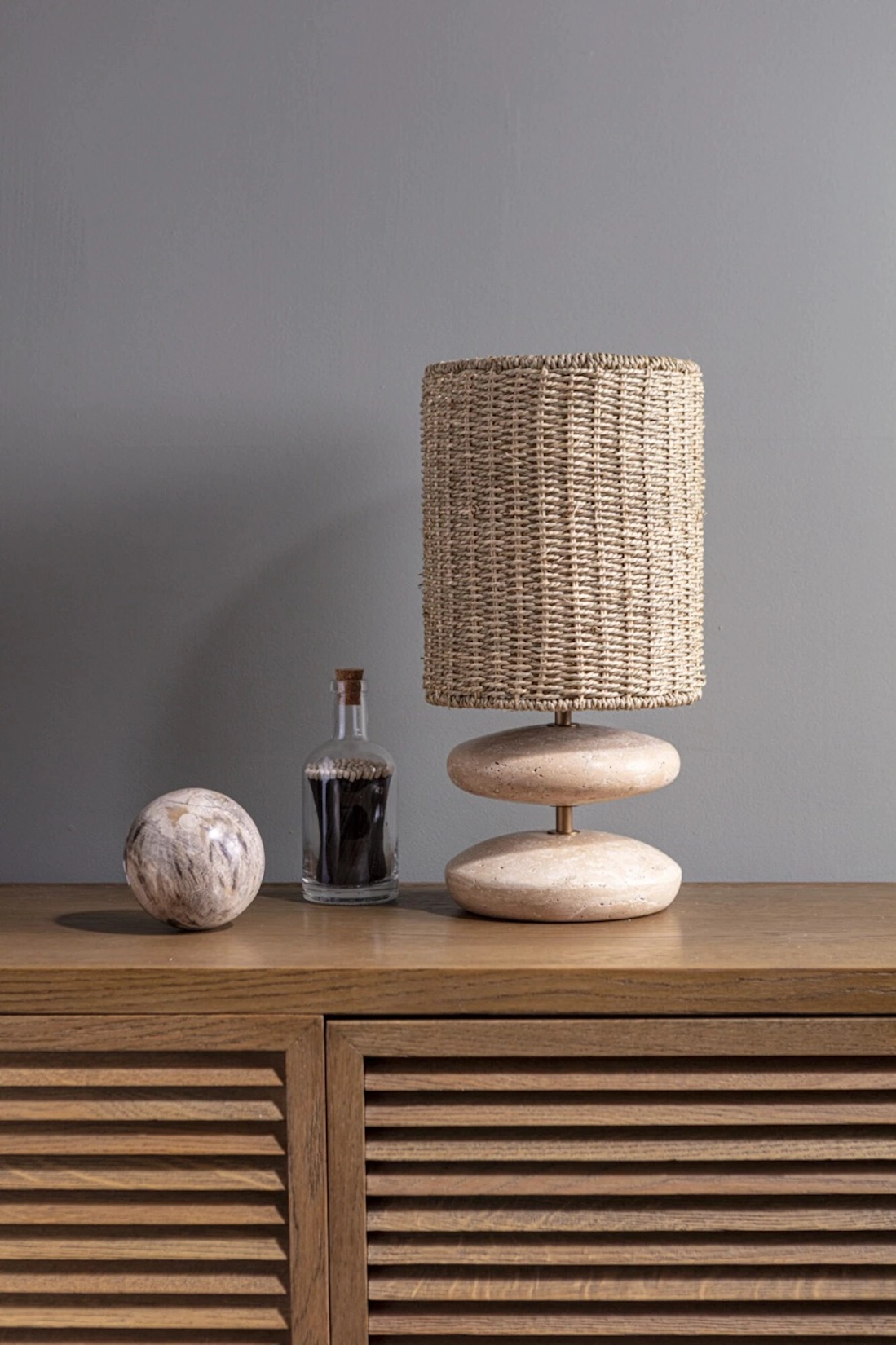 Woven table lamp on a slatted timber sideboard