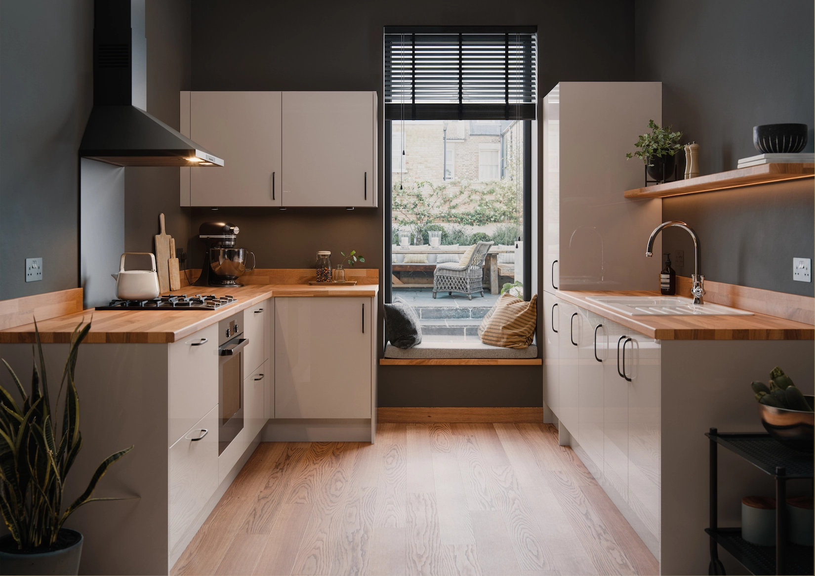 Cream slab kitchen with timber worktop and window seat