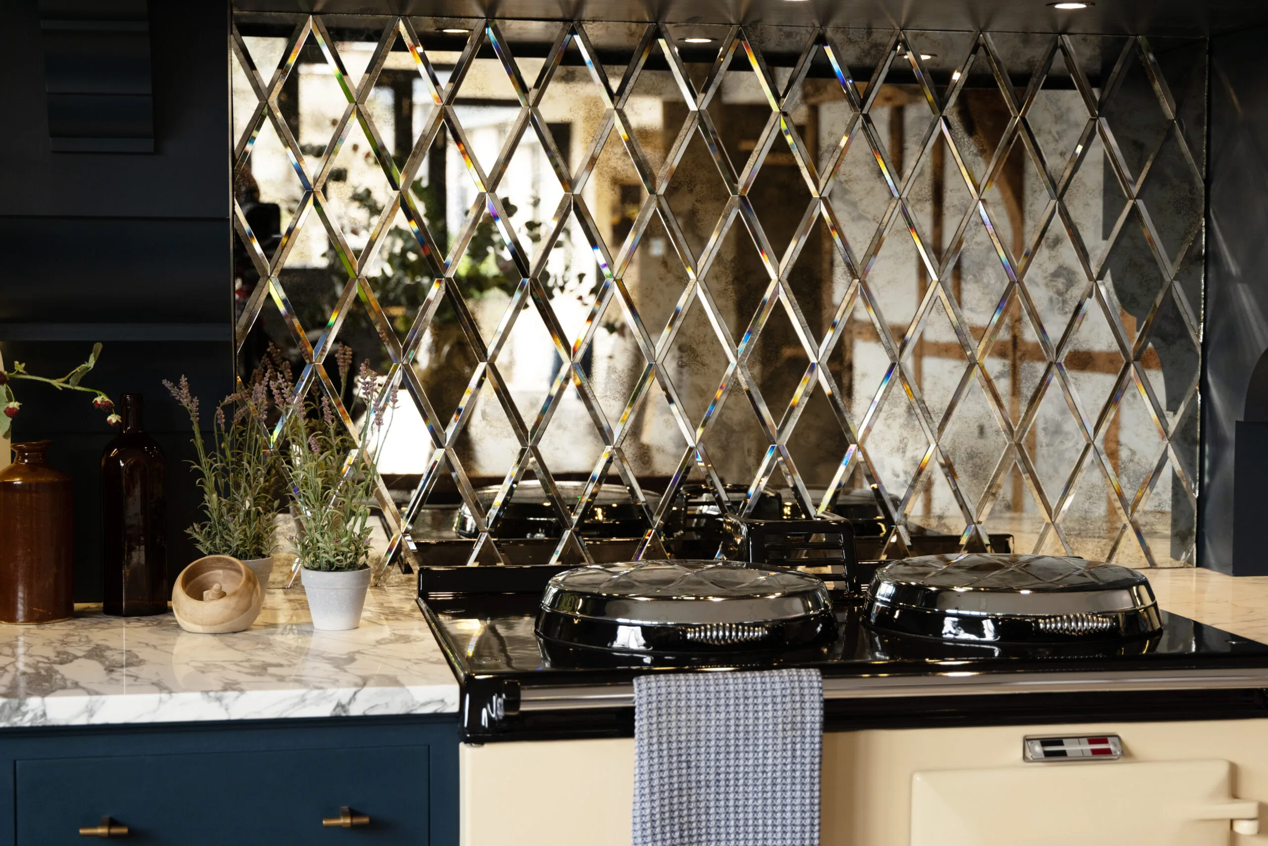 Rococo Diamond mirrored splashback tiles in a mercury finish with a brass shelf
