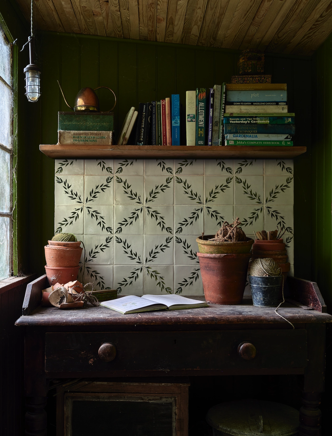 Green study alcove with patterned tiles and antique desk