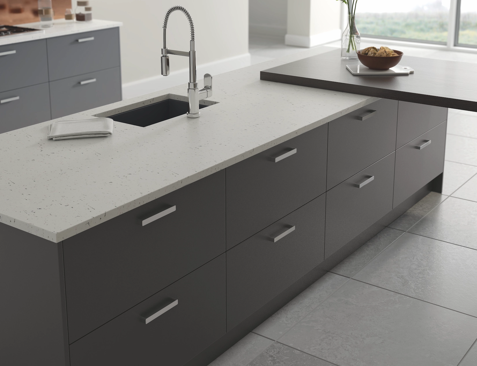 Dark grey slab kitchen island with speckled quartz worktop