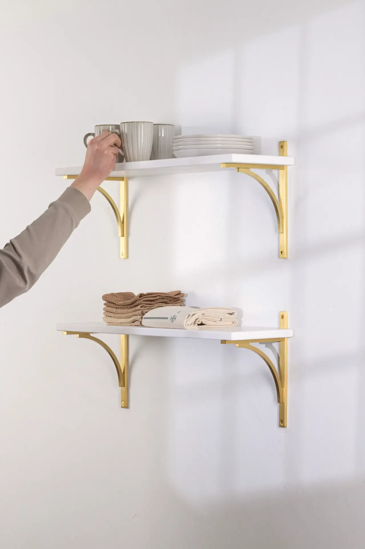 Wall shelves with brass brackets and stoneware