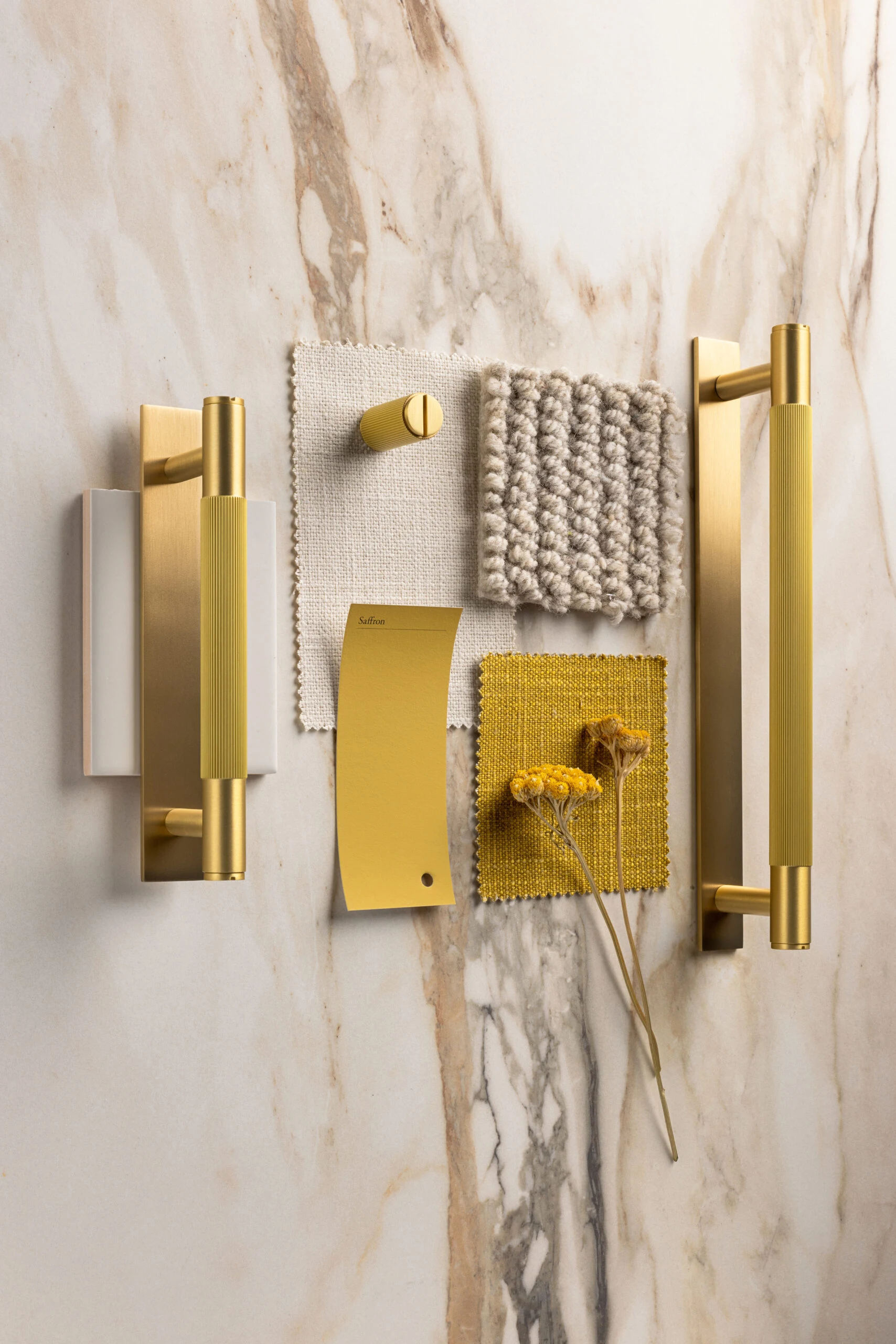 Brass handles and textile samples on calacatta marble
