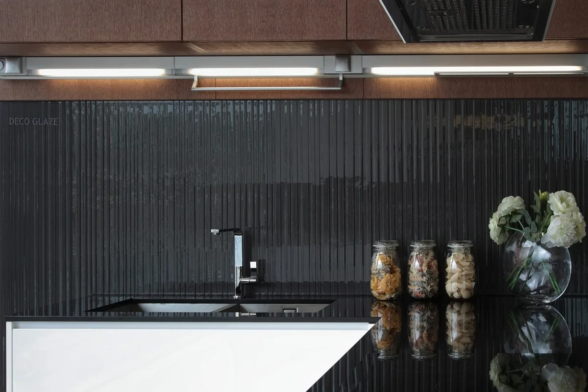 Black fluted splashback tiles behind a matt black kitchen tap