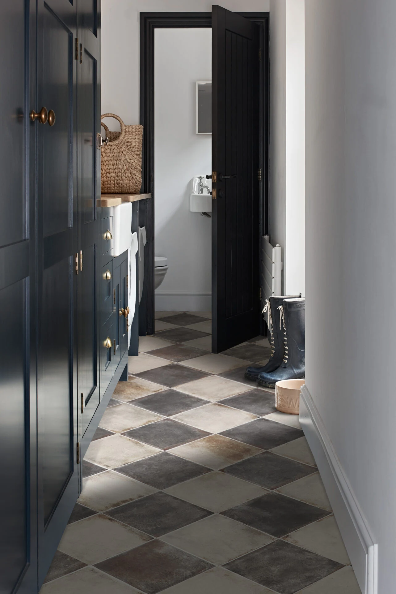 Hallway with checkerboard tiled floor and navy cabinetry