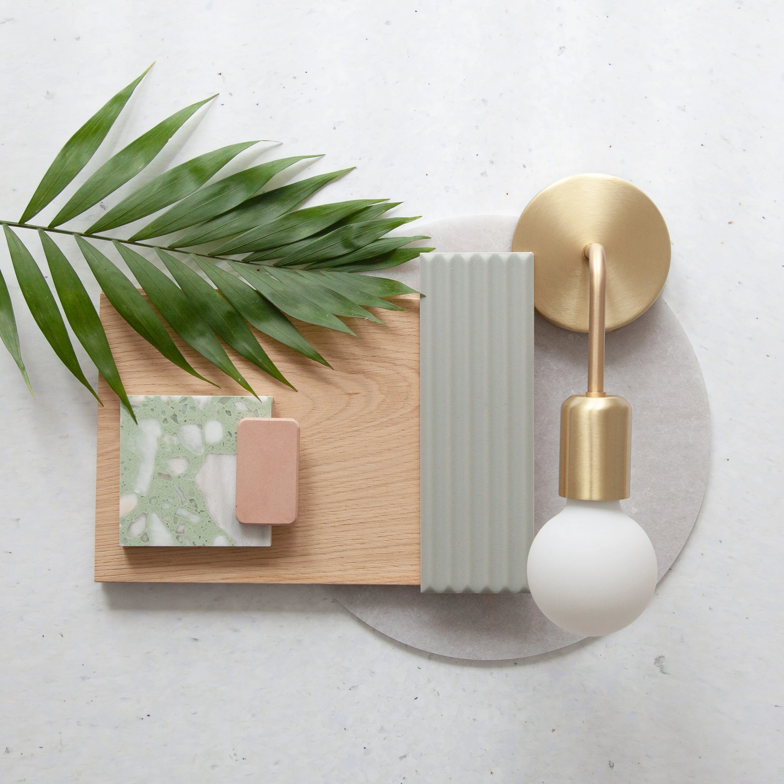Flatlay of kitchen finishes with brass, timber and stone samples