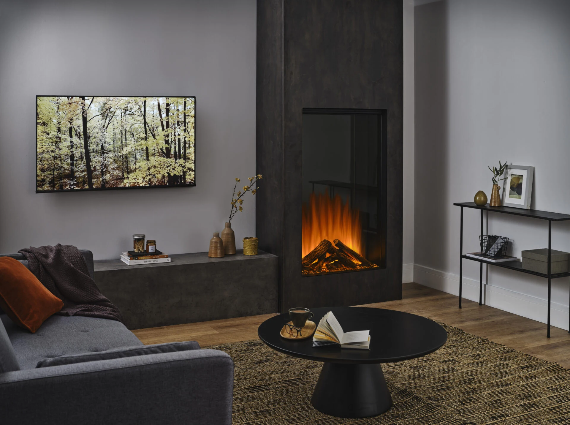 Living room with inset fireplace, wall-mounted television and grey seating