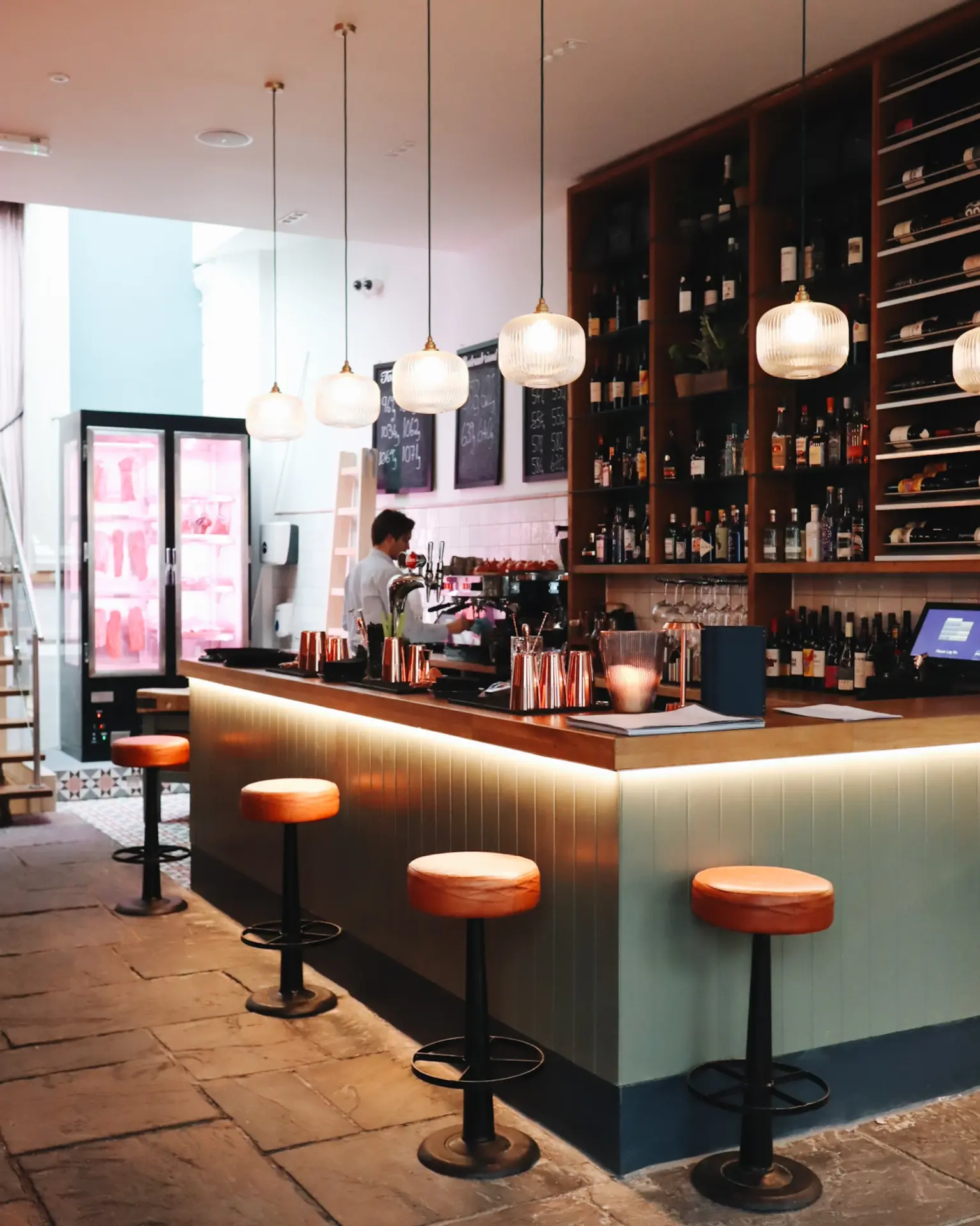 Bar with copper counter, pendant lighting and stools