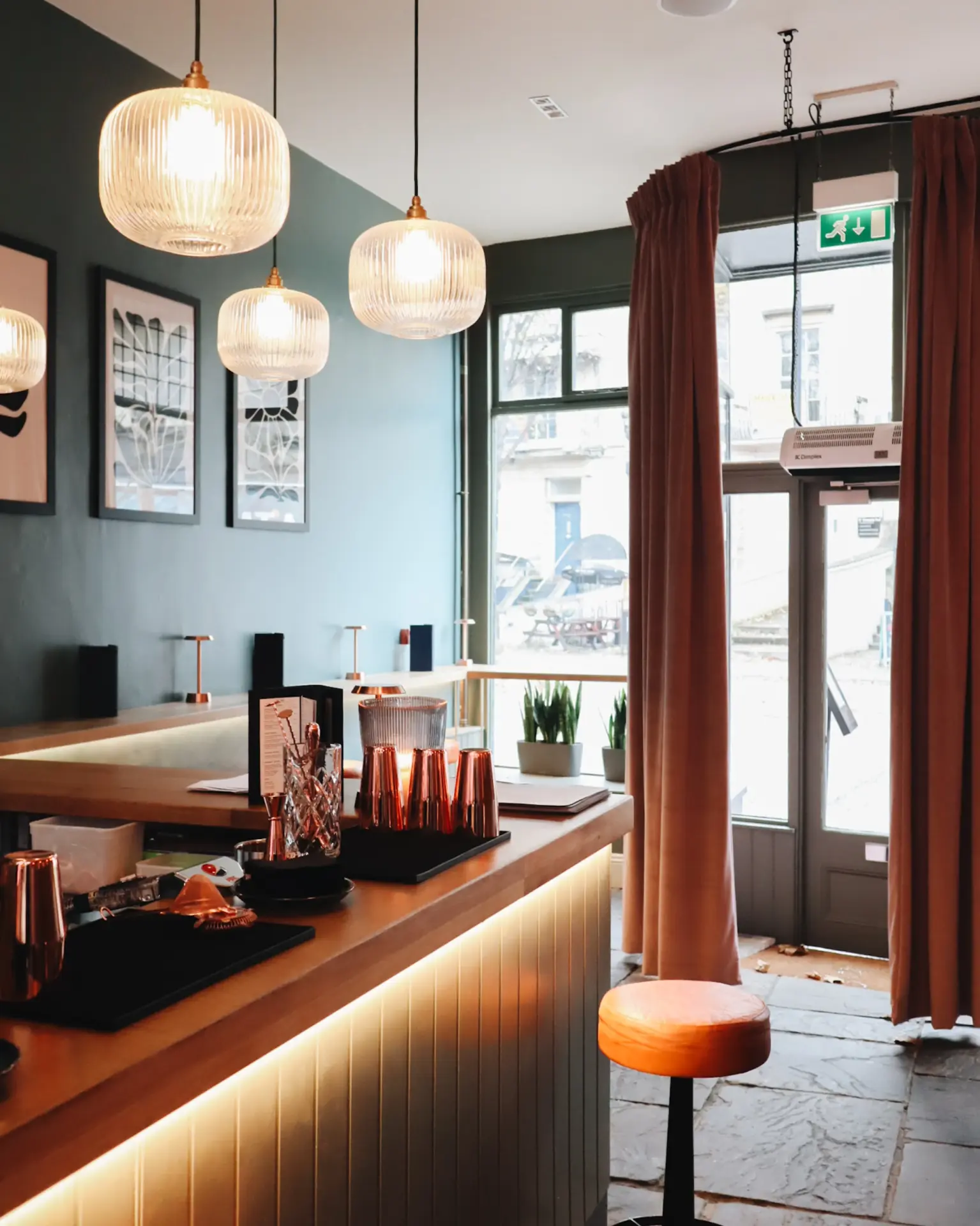 Bar counter with copper top, pendant lights and bar stools