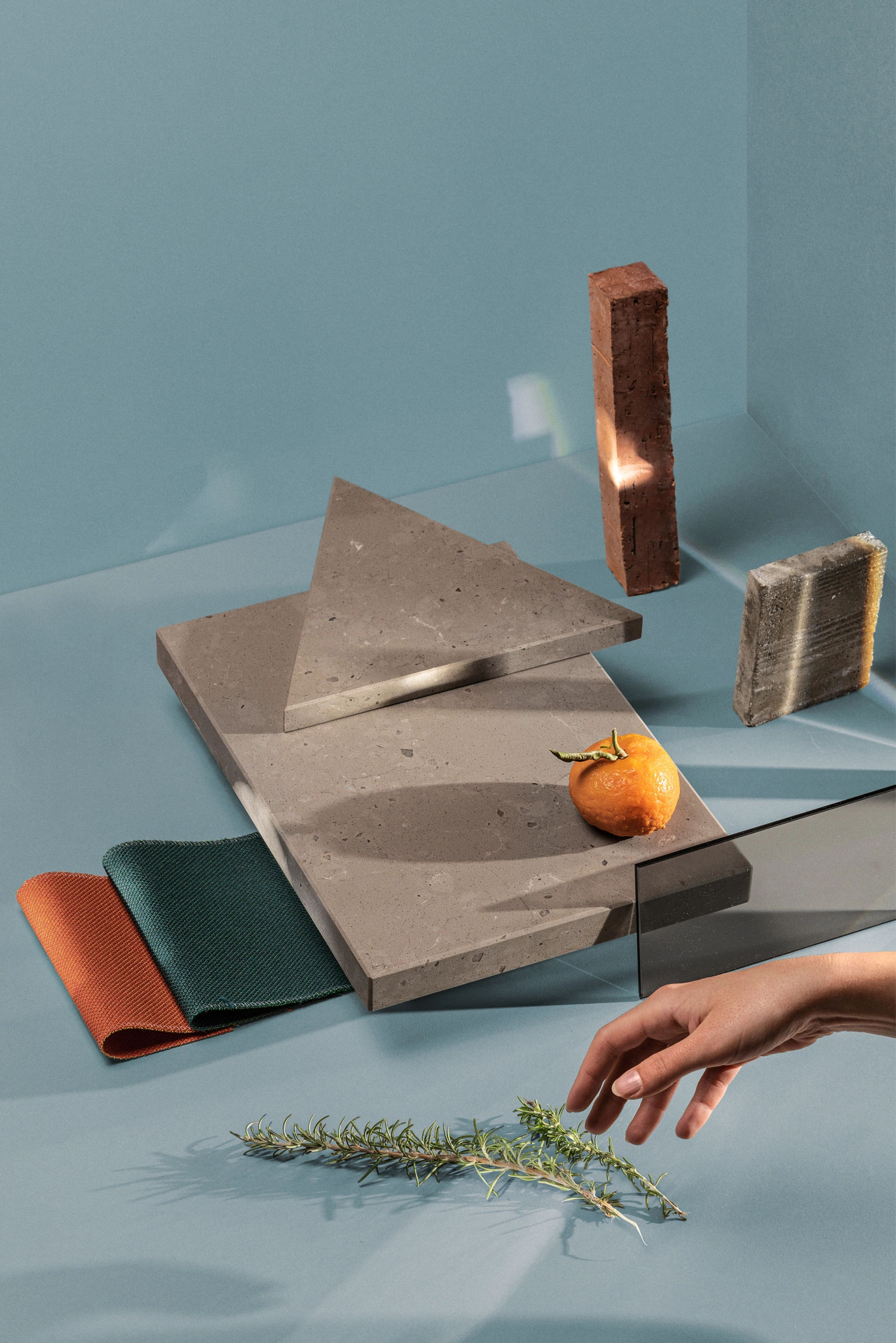 Urban brass moodboard with stone samples on a teal background